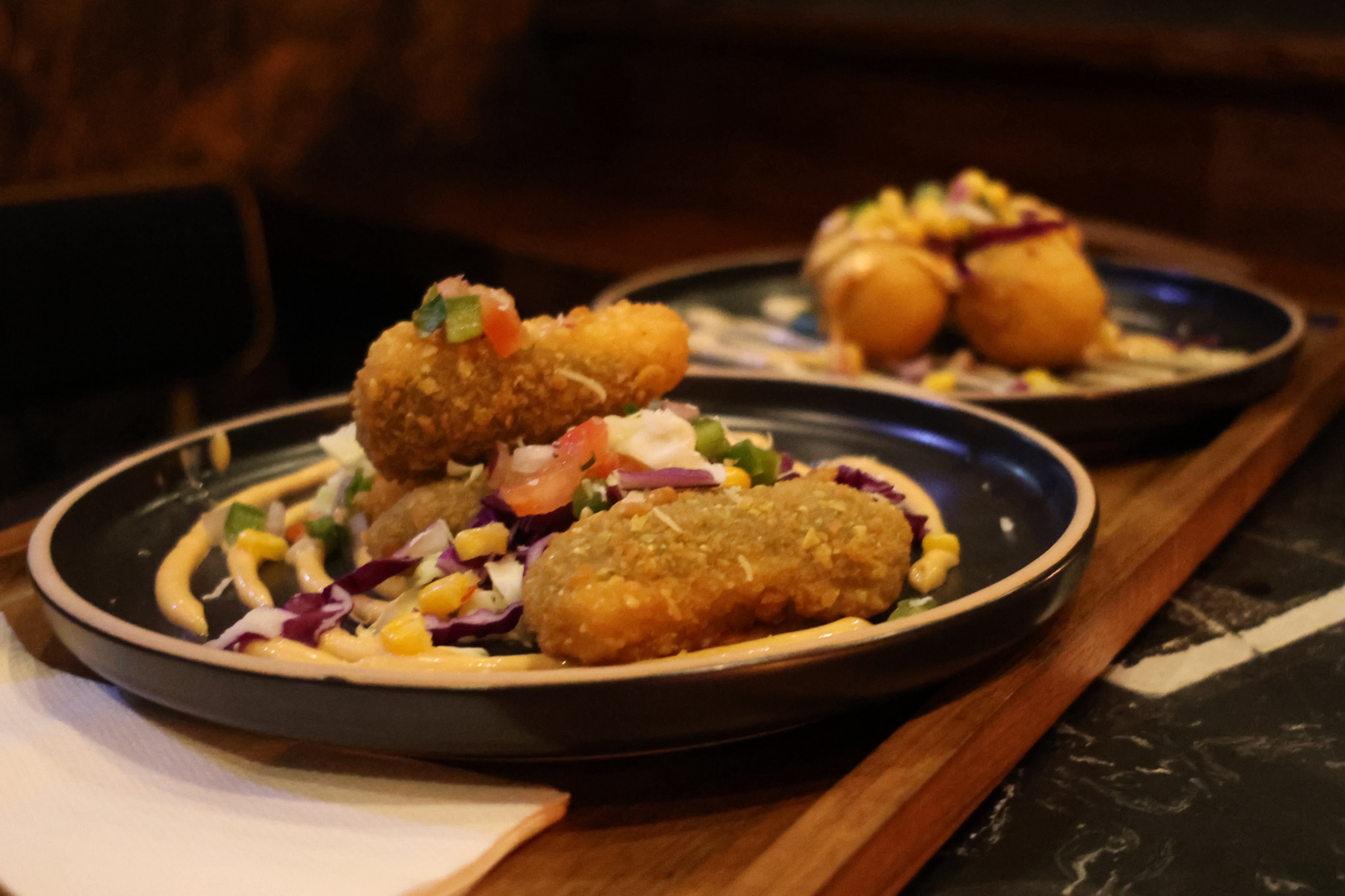 Jalapeño poppers plated with salad at Illumina, from our Instagram